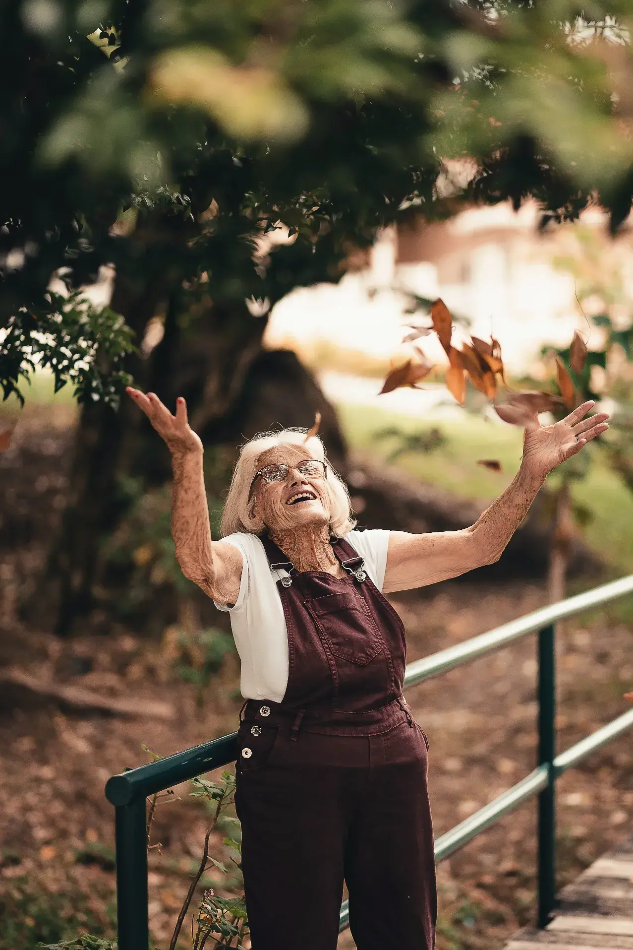 Fröhliche ältere Dame in Iserlohn, die Arme ausgestreckt und die Natur genießt.