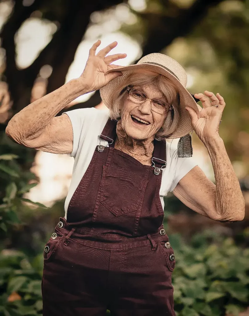 Fröhliche ältere Frau mit Hut posiert in Iserlohn