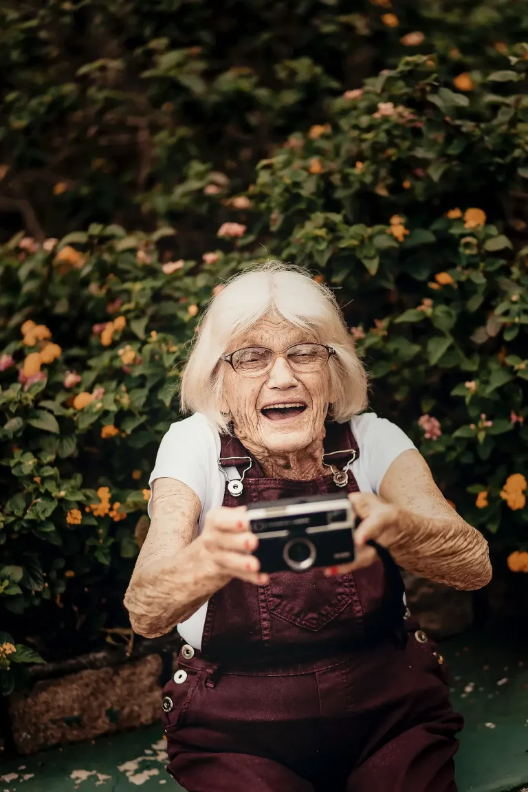 Ältere Dame mit Kamera in Iserlohn, bereit Momente festzuhalten.